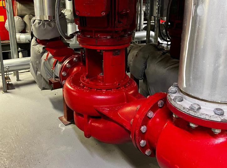 A large red industrial pump unit in a building's plant room